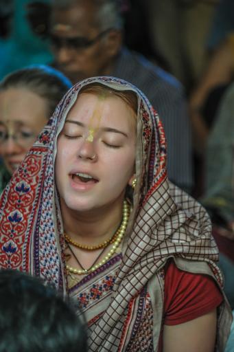 A devotee chanting in a kirtan